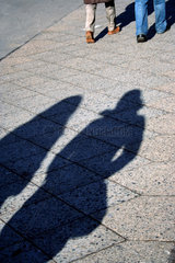 Berlin  Schatten zweier Frauen hinter zwei Maennern