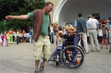 Mann tanzt mit Rollstuhlfahrerin in Poznan  Polen