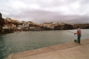 Puerto de Sardina  Gran Canaria  Spanien  Angler vor Fischerdorf-Kulisse