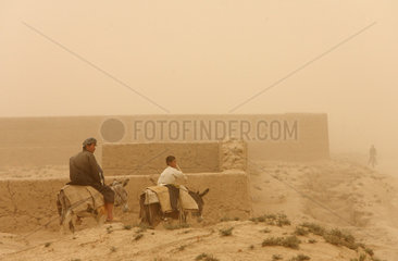 Kunduz  Afghanistan  Vater und Sohn reiten auf Eseln