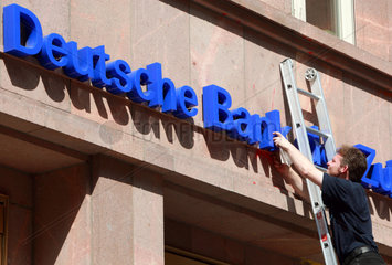 Berlin  Deutschland  Mann putzt den Schriftzug der Deutschen Bank
