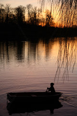 Potsdam  Silhouette eines Jungen in einem Boot in der Abendsonne