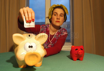 Hausfrau steckt 5 Euro in ein Sparschwein