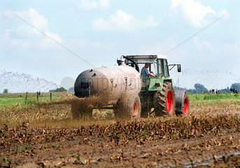 Landwirt bringt Guelle auf einem Feld aus