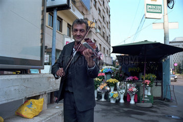 Portraet eines Geige spielenden Sinto in der Innenstadt von Bukarest