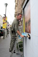 Berlin  Mann klebt Wahlplakat fuer die FDP