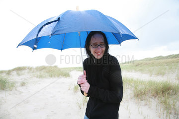 Sankt Peter-Ording  Deutschland  eine Frau geht im Regen am Strand spazieren