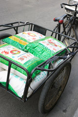 Shanghai  Lasten-Rikscha mit Reissaecken beladen