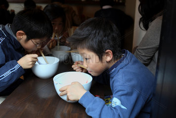 Kamakura  Japan  Kinder in einem Restaurant essen mit Staebchen