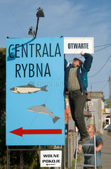 Grossendorf  Polen  Kaschuben montieren Reklameschild fuer ihr Fischgeschaeft