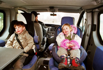 Geschwister auf Kindersitzen im Auto bei einem Familienausflug  Norddeutschland