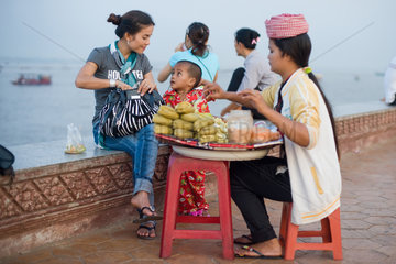 Phnom Penh  Kambodscha  eine junge Frau kauft Obst von einer Strassenhaendlerin