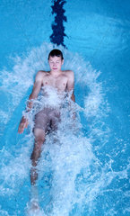 Ein Junge springt ins Schwimmbecken