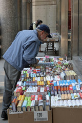 Boston  USA  ein Mann lehnt sich ueber Kartons mit Buechern vor einer Buchhandlung