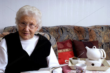 Nauen  Deutschland  eine Rentnerin liest bei einer Tasse Tee