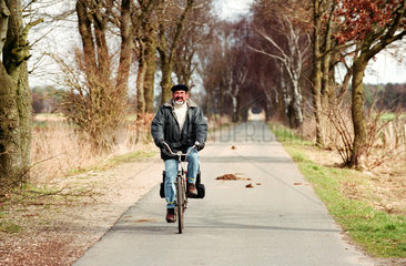 Fahrradfahrer auf einer Landstrasse  Norddeutschland
