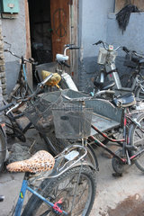 Peking  Fahrraeder und Mopeds vor einem Hauseingang