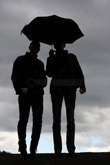 Hannover  Deutschland  Silhouette  Menschen bei Regenwetter unter einem Regenschirm