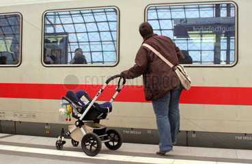 Berlin  Deutschland  Frau mit Kinderwagen am Bahnsteig vor abfahrendem Zug