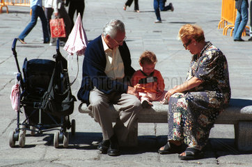 Ein Ehepaar sitzt auf einer Bank mit einem Kind