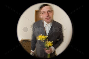 Freiburg  Deutschand  Mann steht mit Blumen an der Tuer