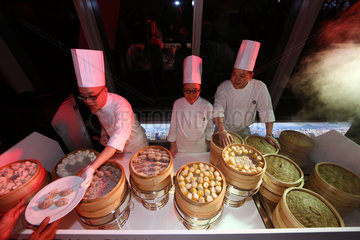 Hong Kong  China  Koch reicht einem Gast einen Teller mit Dim Sum