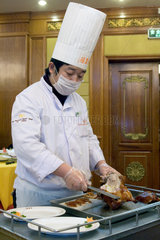 Peking  Koch beim Zerteilen einer Pekingente im Quanjude Roast Duck Restaurant