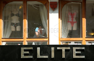 Karlsbad  Tschechische Republik  eine Putzfrau wischt Schaufenster eines Dessousgeschaeftes