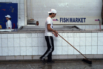 Mann macht nach dem Verkaufsschluss beim Fischmarkt sauber  Bukarest