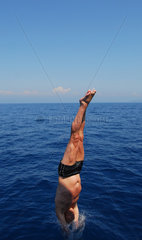 Portoferraio  Italien  ein junger Mann springt kopfueber ins Meer  Bucht Sansone