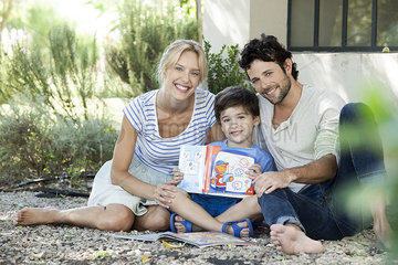 Parents together with child learning to read  portrait