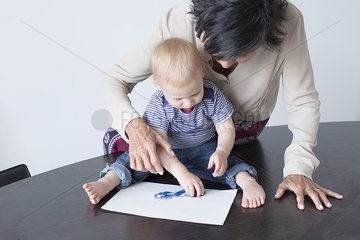 Grandmother and baby drawing together