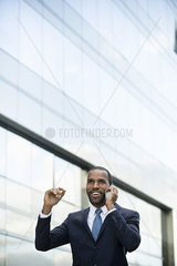Businessman talking on cell phone and smiling outdoors