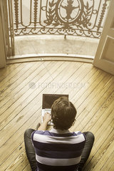 Man sitting on floor using laptop computer