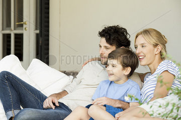 Family with one child relaxing together outdoors