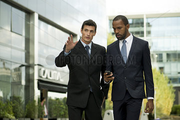 Businessmen walking and talking together outdoors