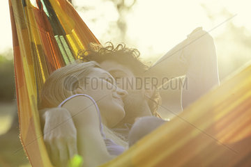 Couple napping together in hammock