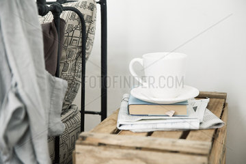 Coffee cup and book on night table