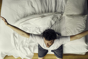 Man stretching in bed
