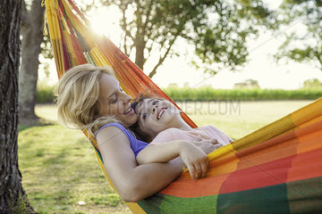 Mother and son relaxing in hammock together