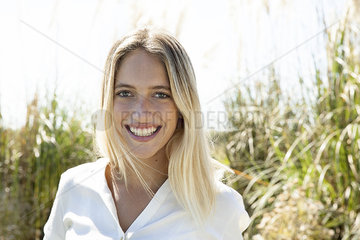 Woman smiling cheerfully outdoors  portrait
