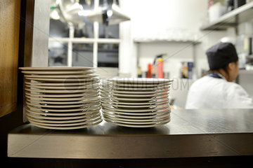 Stack of plates on shelf in commercial kitchen