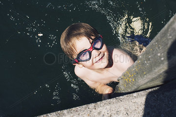 Boy with goggles swimming in water