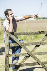 Farmer making phone call to report problem on farm
