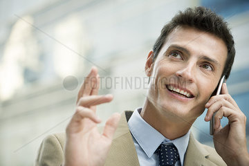 Cheerful businessman talking on cell phone