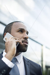 Businessman talking on cell phone outdoors