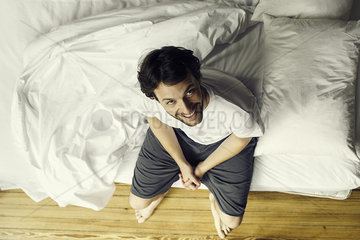 Man setting on edge of bed