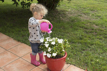 Little girl watering potted plants