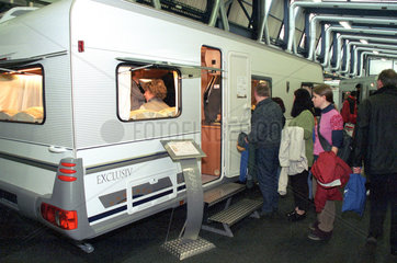 Menschen besichtigen einen Wohnwagen auf einer Messe