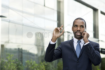 Businessman talking on cell phone outdoors